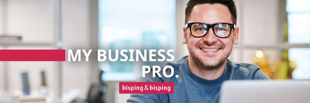 Junger Mann mit Brille an Laptop in modernem Büro – Symbolbild für produktives Arbeiten mit dem Tarif ‚My Business Pro‘ von Bisping & Bisping